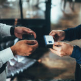 名刺交換する大家と不動産営業担当者